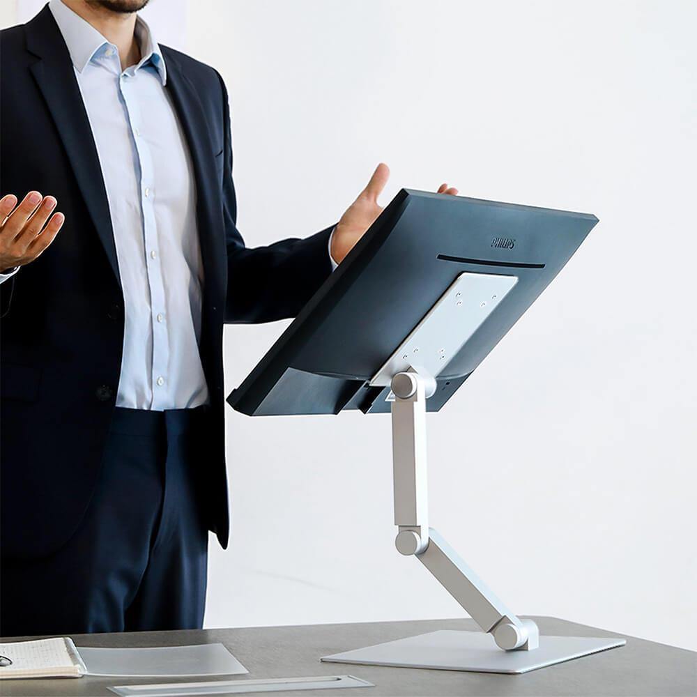 Maxtand monitor arm alternative silver white, man wearing shirt and suit standing, doing performance with PC monitor having meeting in meeting room office 